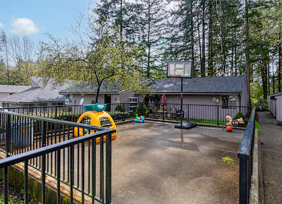 A yellow toy car is parked on a concrete driveway.