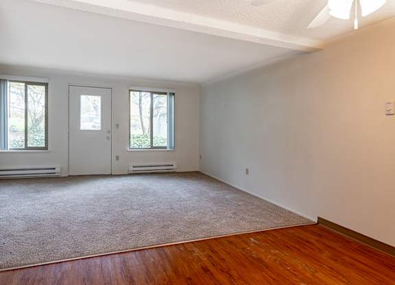 A room with a carpeted floor and a white wall.