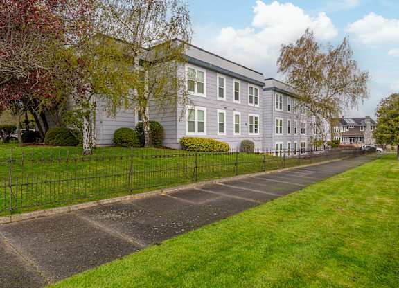 A long building with a fence in front of it.