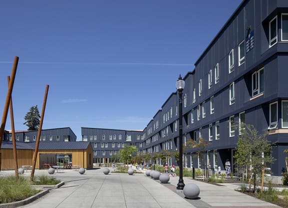 a courtyard in front of a building with a blue sky in the background