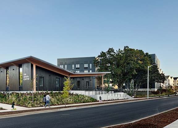 A modern building with a person walking in front of it.