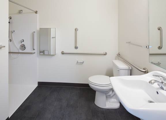 A white bathroom with a toilet, sink, and shower.