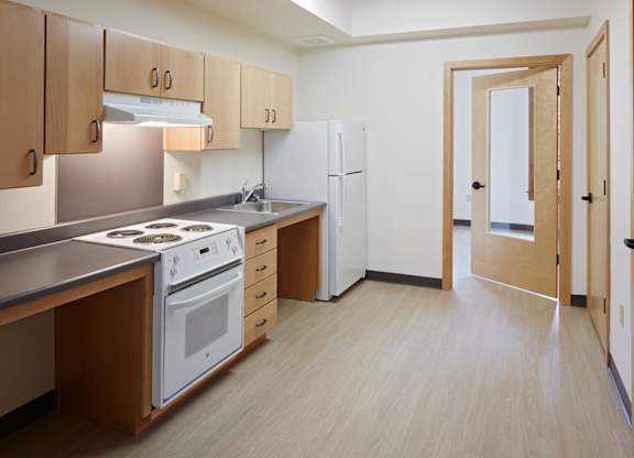 A kitchen with a white refrigerator and a white stove top oven.