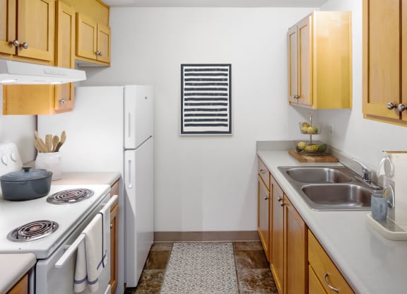 a kitchen with white appliances and wooden cabinets