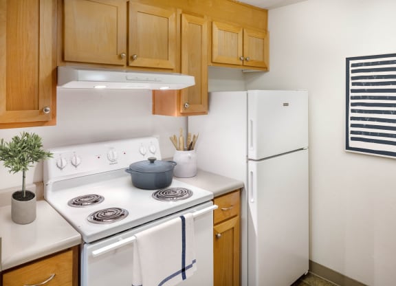 a kitchen with white appliances and wooden cabinets