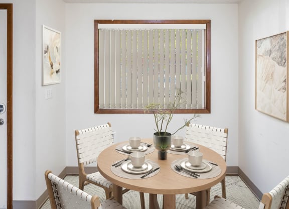 a small dining room with a wooden table and white chairs