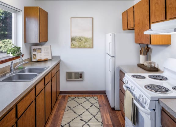 a kitchen with white appliances and wooden cabinets
