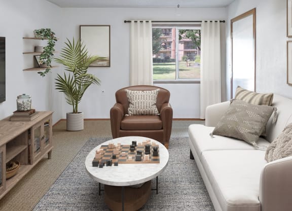 a living room with a couch chair and coffee table with a chess board on top of it