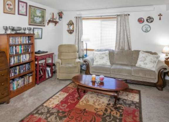 A living room with a couch, chair, and bookshelf.