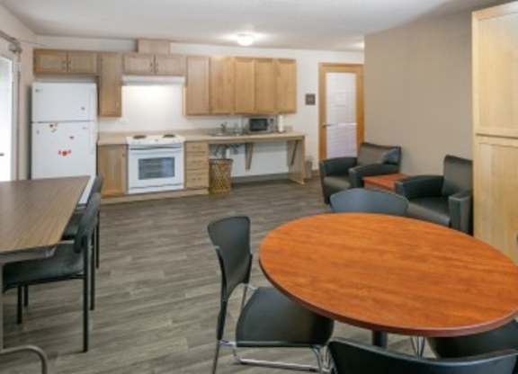 A kitchen with a dining table and chairs.