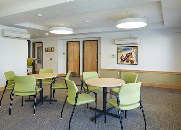 A conference room with green chairs and a white table.