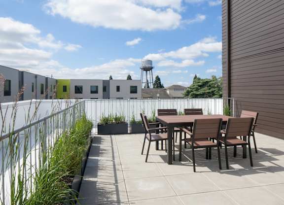 A patio with a table and chairs is in front of a building.
