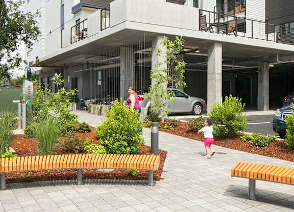 A modern building with a courtyard and a small child walking.