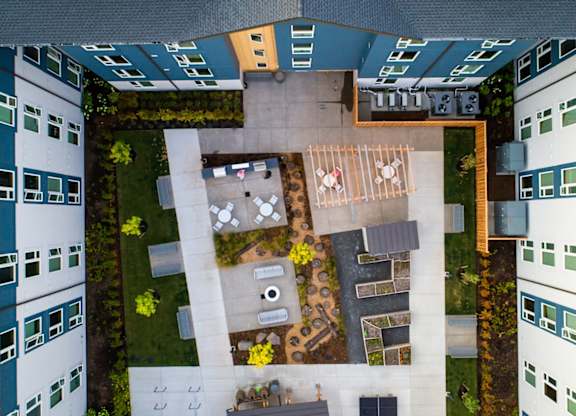 A courtyard surrounded by buildings with a table and chairs.
