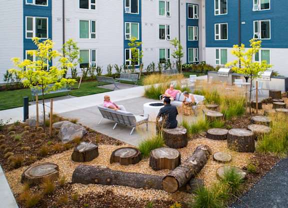 A small garden with a bench and a tree.