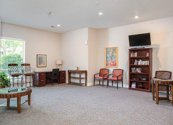 A living room with a carpeted floor and a bookshelf.