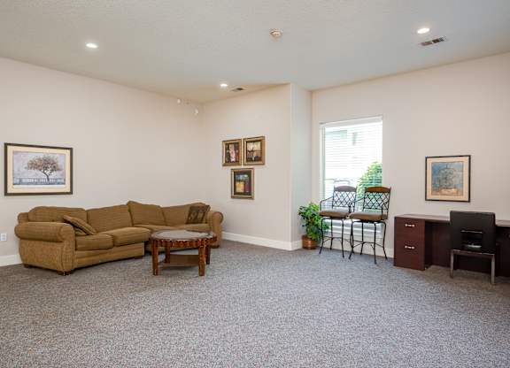 A living room with a couch, chair, and pictures on the wall.