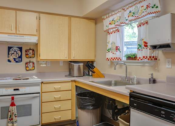 A kitchen with wooden cabinets and a white oven.