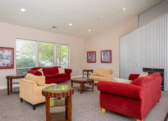 A living room with a red couch and a fireplace.