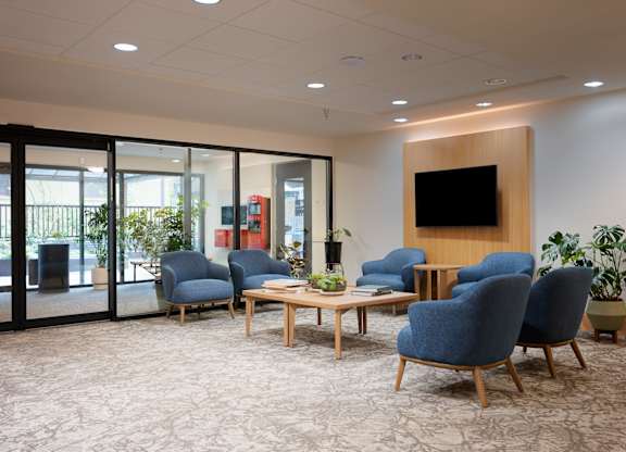 A conference room with blue chairs and a wooden table.