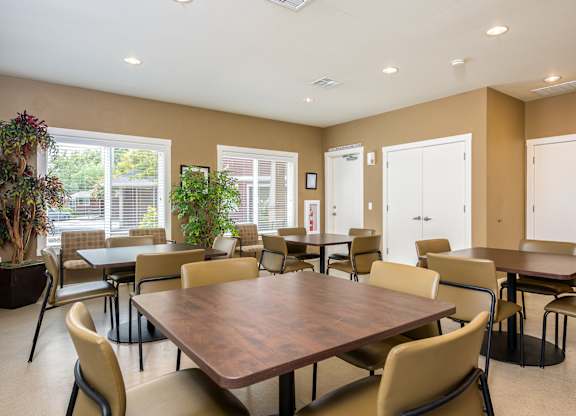 A large brown table surrounded by chairs in a room with brown walls.