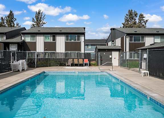 A swimming pool in front of apartment buildings.