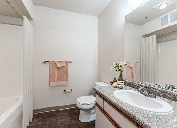 A bathroom with a white tub, toilet, and sink.