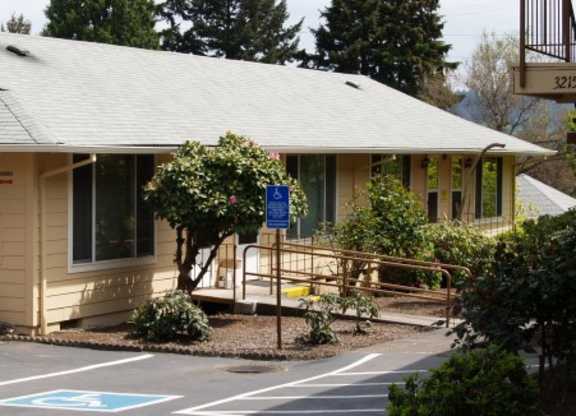 A small building with a parking spot in front.