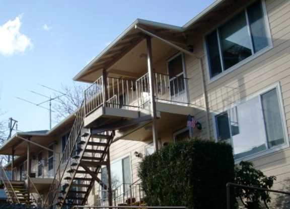 A two-story house with a balcony and a staircase leading to the second floor.