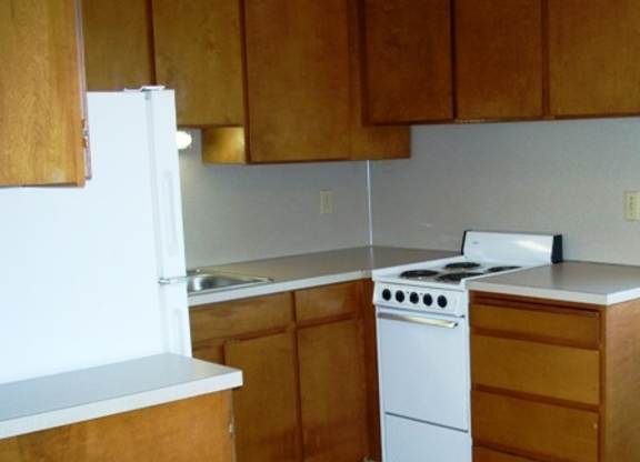 A white stove and oven in a kitchen with wooden cabinets.