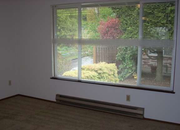 A room with a window covered in blinds.
