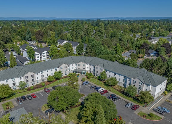 A large white building with a parking lot in front of it.