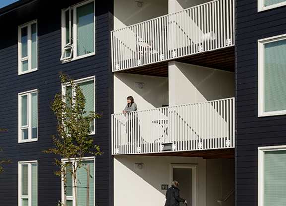 A woman is walking her dog on a balcony.