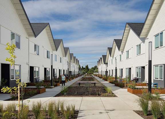 A row of white houses with a person walking in the middle.