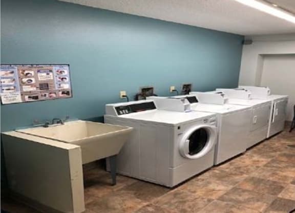 a laundry room with two washing machines and a sink