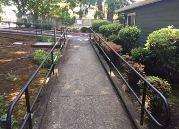 a walkway in a garden with a house