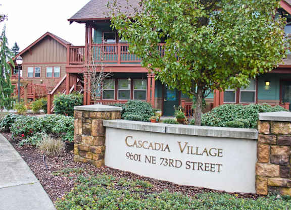 A sign that says Cascadia Village stands in front of a building.