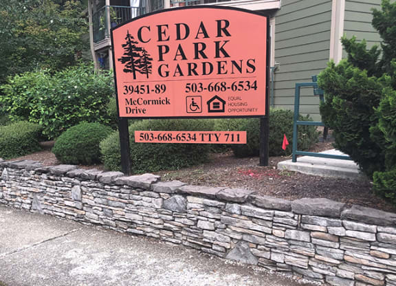 a sign for cedar park gardens in front of a building
