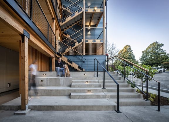 a man and a dog standing on the stairs of a building