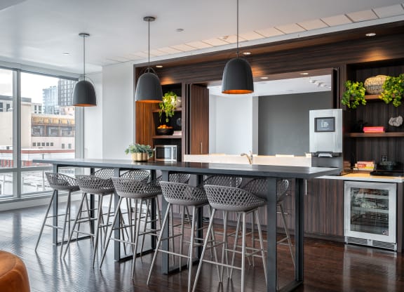 a kitchen with a large island with bar stools and chairs