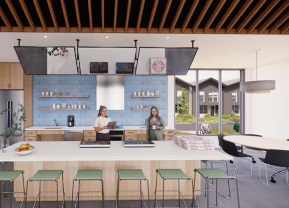 Two people are standing behind a counter in a modern kitchen.