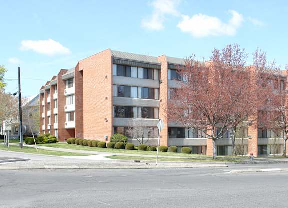 A large brick building with a tree in front of it.