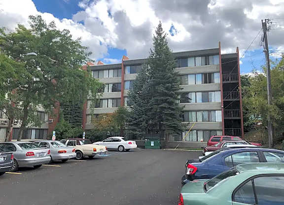 A parking lot with cars and a building in the background.