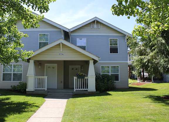 A two-story house with a front porch and a white door.