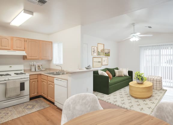 a living room and kitchen with a dining table and a green couch