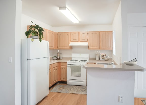 a renovated kitchen with white appliances and wooden cabinets