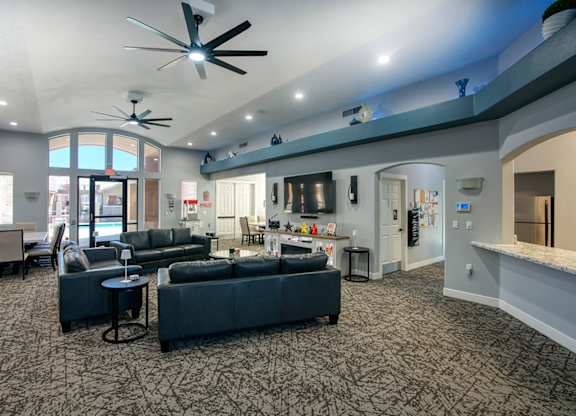 A spacious living room with a grey carpet and furniture.