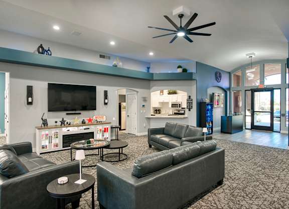 A spacious living room with grey couches and a television.