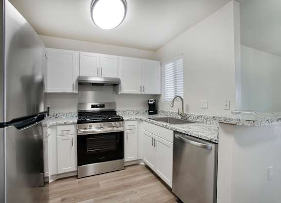 A modern kitchen with stainless steel appliances and white cabinets.