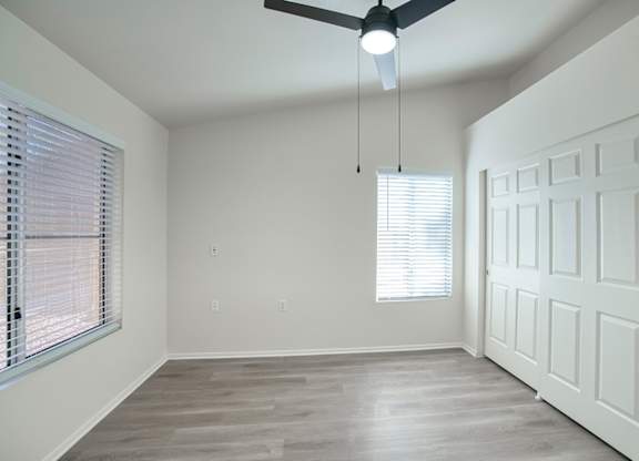 A room with a ceiling fan and a door.